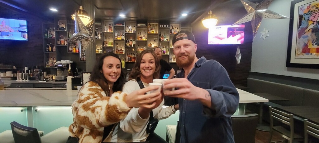 Group toasting drinks at bar on a fun mad cat tours pub crawl